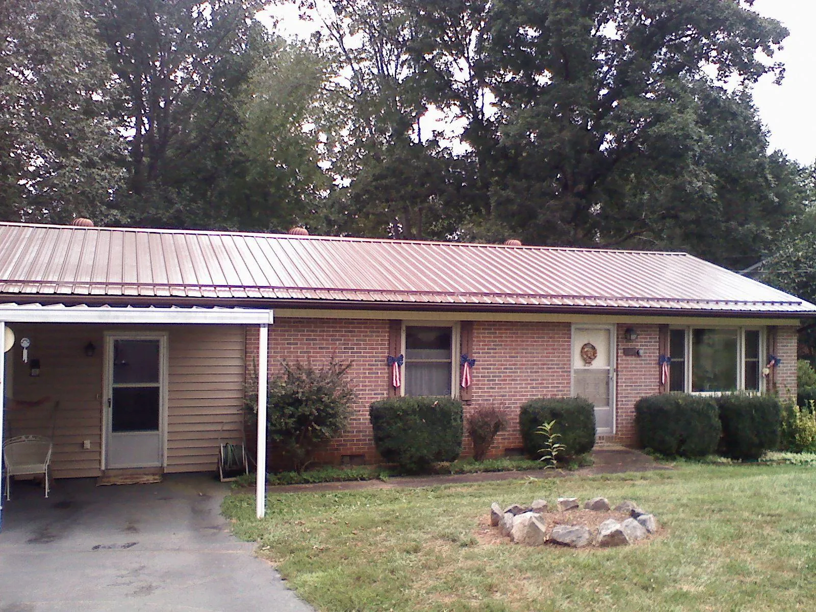 Bronze metal roof and carport on a brick ranch home — Roof Repair work by our crew in Glenarm